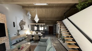 Ein modernes Wohnzimmer mit einer Couch, einem Esstisch und einer Treppe.