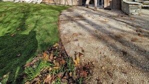 Uma cabana moderna de madeira com janelas amplas, um pátio de concreto e uma escadaria que leva a um deck.
