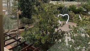 Vista desde una ventana con vista a un paisaje montañoso y una escultura con forma de corazón en primer plano.