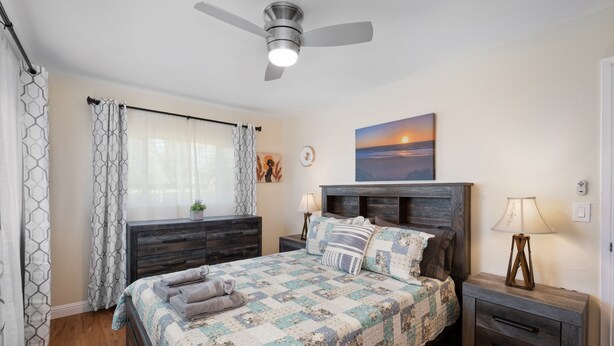 A bedroom with a bed, a nightstand, a lamp, a ceiling fan, and a painting on the wall. - 3B/2Bth Clean, Cozy, Convenient (Fresno)