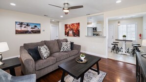 A living room with a sofa, coffee table, and artwork on the walls. - 3B/2Bth Clean, Cozy, Convenient (Fresno)