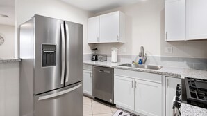 A modern kitchen with stainless steel appliances, white cabinets, and granite countertops. - 3B/2Bth Clean, Cozy, Convenient (Fresno)
