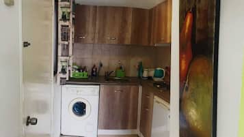 Een koelkast, een magnetron, kookgerei, borden en bestek