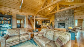 Relax in a cozy cabin with a warm fireplace, comfortable seating, and a modern kitchen.