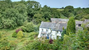 A traditional house surrounded by lush greenery and trees. - 2 bed rural retreat nestled in the heart of Exmoor (Parracombe)
