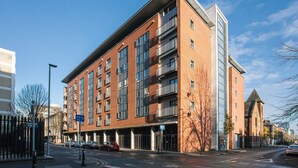 Un immeuble à plusieurs étages doté d’une architecture moderne, caractérisé par de grandes fenêtres et une façade en briques.