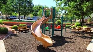 A playground with a slide, benches, and a picnic table. - 2 bedroom private villa, with pools & hot tubs! (St. George)