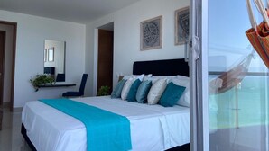 Una camera da letto moderna con un letto grande, una scrivania e una sedia. In evidenza, due quadri appesi al muro.