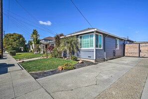A single-story house with a front yard, a driveway, and a wooden fence. - Cozy Bay Area Vacation Rental with Patio (Hayward)