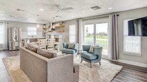 A modern living room with a sofa, chairs, a dining area, and a kitchen. - Walk to Beach & Bay: Galveston Home w/ Pier Access (Galveston)