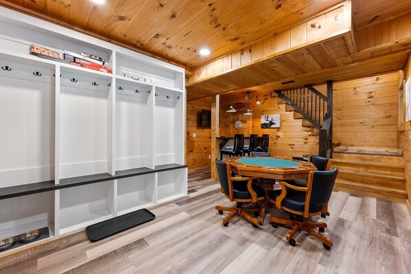 Un intérieur en bois comprenant une table de billard, des chaises et un porte-chaussures.