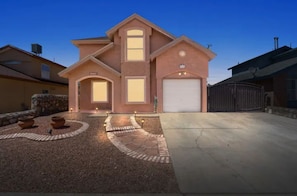 Stunning home with a central entrance, flanked by two windows, and a charming garden.