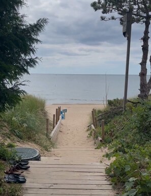 A wooden pathway leading to a beach with a sign indicating private property. - Blue Anchor Beach Home: Private Beach Access, Large Family Room, Spacious Accommodations (Holland)