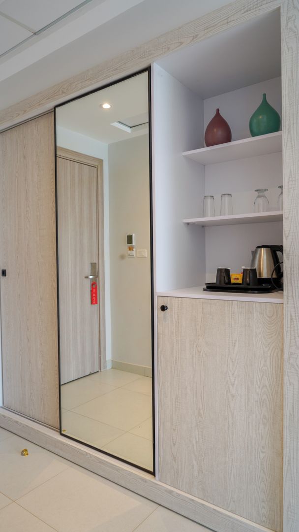 A modern room with a sliding door, a white cabinet with shelves, and a coffee maker.
