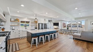 Une cuisine moderne dotée d’un îlot central, de tabourets de bar et d’un coin repas offrant une vue agréable.