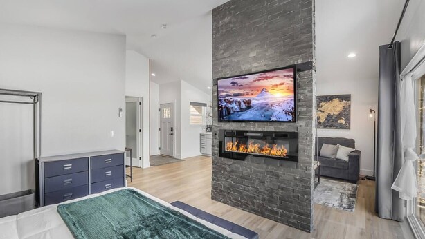 Ein modernes Wohnzimmer mit Kamin, Flachbildfernseher und einer gemütlichen Sitzecke.