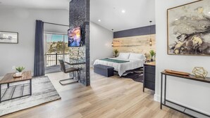 Ein modernes Schlafzimmer mit Bett, Schreibtisch und Fernseher.