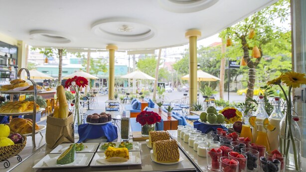 A café with a variety of pastries, fruits, and beverages on display. - Cocochine a VIE Collection (Da Nang Municipality)
