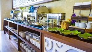 A buffet setup with multiple coffee machines, a variety of bowls and plates, and a wicker basket. - Cocochine a VIE Collection (Da Nang Municipality)