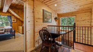 L’intérieur d’une cabane en bois comprend un coin repas, un escalier et un lit.