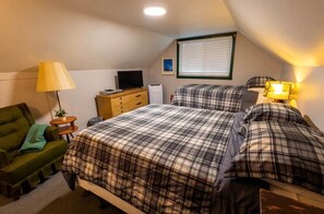 A small, cozy room with two beds, a desk, a chair, and a television. - Rivers Resort Cabin #6 (Strawberry)