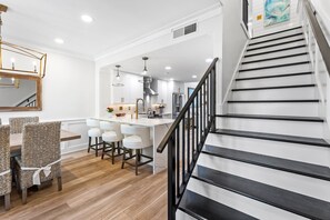 A modern kitchen with a central island, white cabinetry, and stainless steel appliances. - "Beachwalk Landing" Perfect in Every Way!  Includes Cart for Your Stay (Destin)