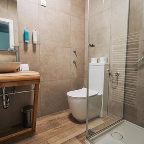 A bathroom with a wooden vanity, a glass shower enclosure, and a toilet. - Rezidenca Ortus (Ankaran)