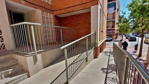 Portaikko, jossa on metallikaiteet, johtaa rakennuksen sisäänkäyntiin.