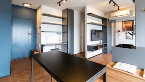 Ein moderner, gut beleuchteter Raum mit einem schwarzen Tisch, eingebauten Regalen und einer hölzernen Bank.