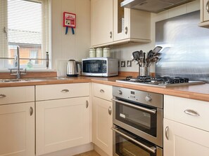 A kitchen with a microwave, stove, oven, and stainless steel appliances.