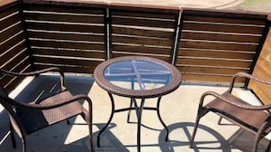 Un'area patio con un tavolo rotondo e due sedie in vimini.