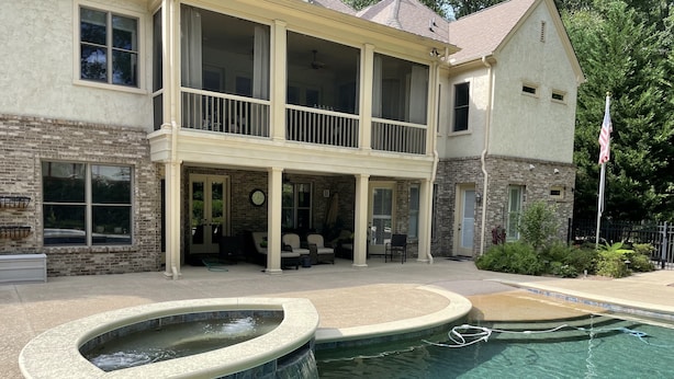 A two-story house with a swimming pool, outdoor seating, and a flag. - Private Vacation Resort:  Pool,  Spa, Gym, Kitchen, Laundry, in Tranquil Setting (Sugar Hill)