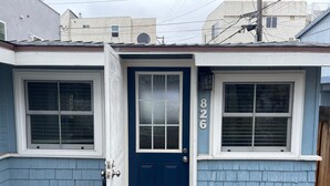A two-story house with a blue door and windows, numbered 826. - Bayside Cottage - Steps from the Bay and Ocean with AC (San Diego)