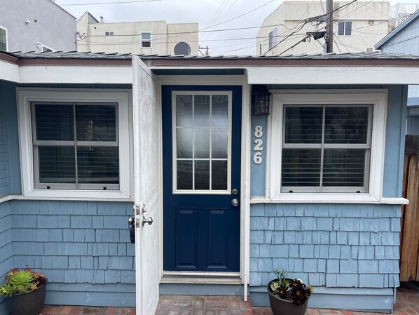 A two-story house with a blue door and windows, numbered 826. - Bayside Cottage - Steps from the Bay and Ocean with AC (San Diego)