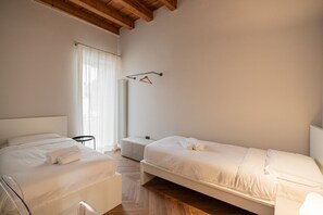 Une chambre avec deux lits, une petite table et une lampe suspendue.