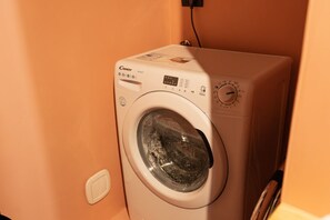 Une machine à laver à chargement frontal dotée d’un panneau de commande, d’un écran numérique et d’un sélecteur permettant de régler le cycle de lavage.