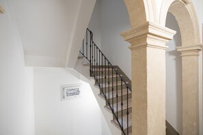 A staircase with black balusters and stone steps, leading to a landing with a framed picture. - Elegant Frescoed Residence 200 meters from the Arena (Verona)