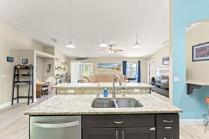 Enjoy meals in the kitchen with a central island and dining area, offering a view of the outdoors.