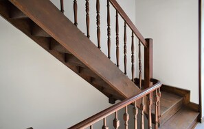 Una scala in legno con ringhiera e balaustre.