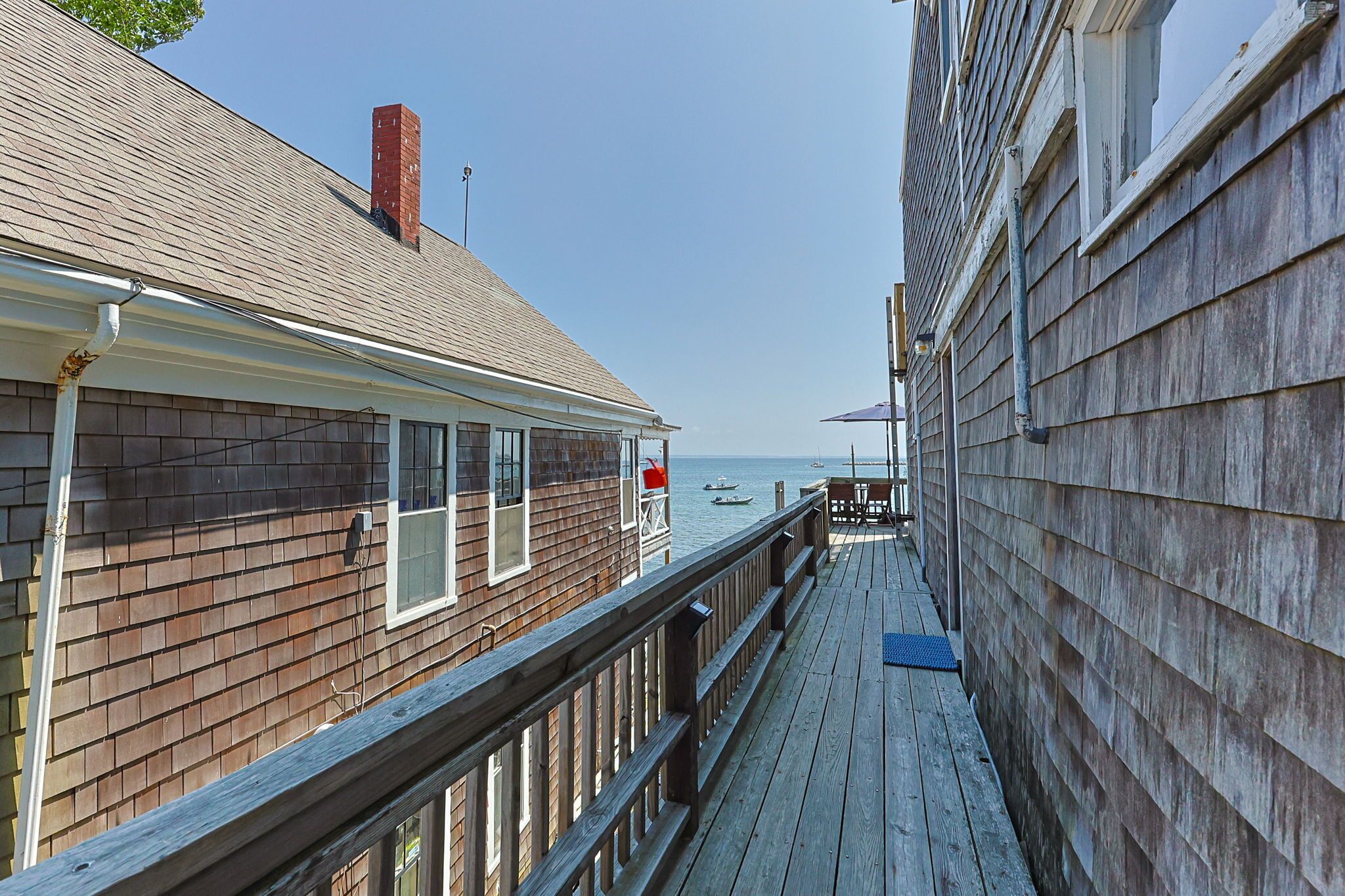 Eine Holzterrasse mit Blick auf das Meer und Boote.