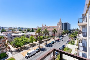 Paisagem urbana com uma igreja imponente, edifícios modernos e um céu azul límpido.