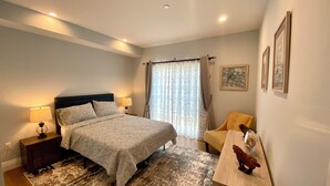 A bedroom with a bed, nightstands, a chair, a rug, and a wall with framed pictures. - Private Cozy Spacious Condo Unit with Gym— Walk distance to market (Los Angeles)