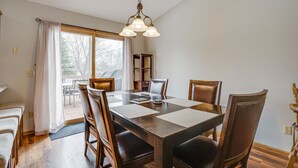 Un coin repas avec une table en bois, des chaises et un lustre.