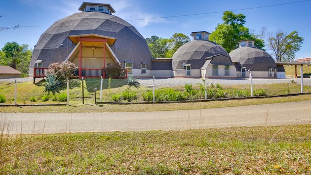 Una casa con un tetto a cupola particolare e una porta rossa.