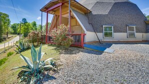 A house with a sloped roof, a covered porch, and a gravel driveway. - Unique Country Getaway in Angie w/ Covered Patio! (Angie)