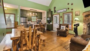 Een rustiek chaletinterieur met een eethoek, keuken en woonkamer.