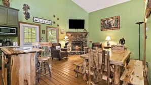 Un intérieur rustique avec une cheminée en pierre, des meubles en bois et un mur végétal.