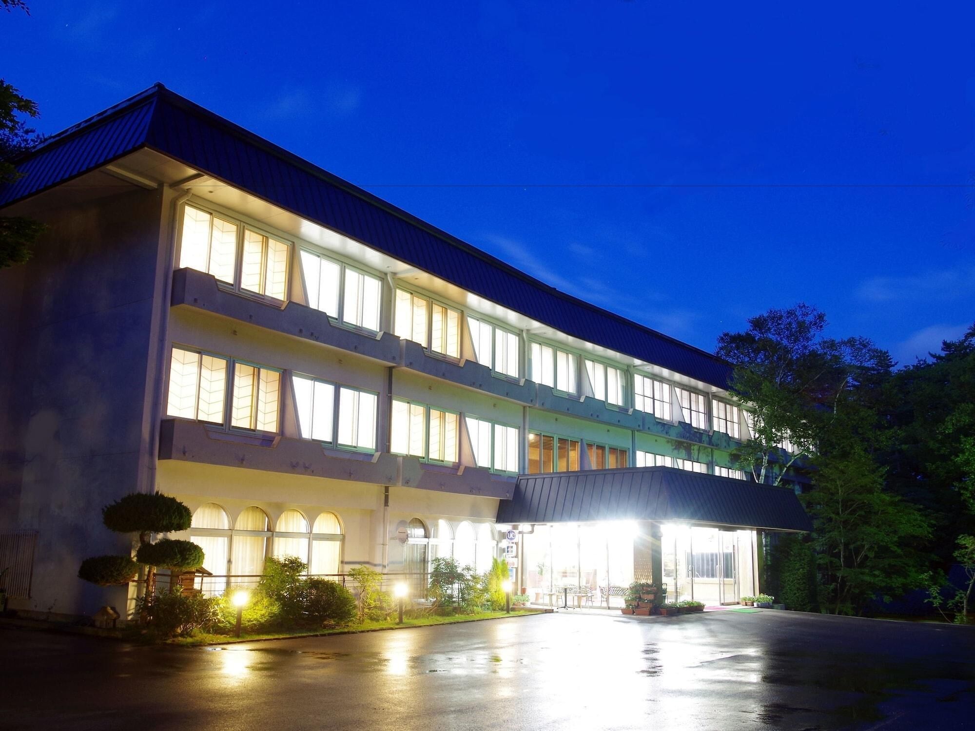 A multi-story hotel with a flat roof and large windows.