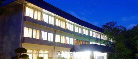A multi-story hotel with a flat roof and large windows.