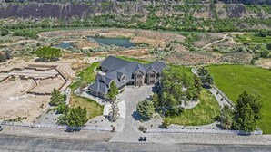 A large house with a driveway and a fenced yard. - Canyon Rim Retreat (Filer)